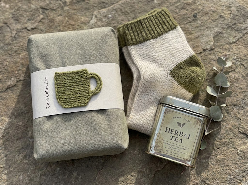 A green wrapped parcel, tea and woollen socks